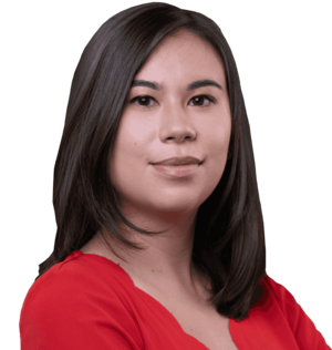A headshot of a woman with light skin and long, dark hair wearing a bright red blouse.